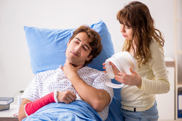 Obraz na płótnie Canvas Loving wife looking after injured husband in hospital 