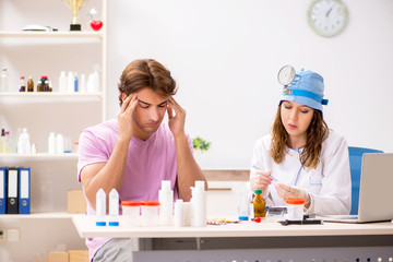 Obraz premium Young handsome man visiting young female doctor otolaryngologist