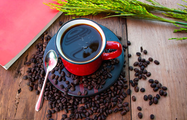 Coffee red cup Roasted coffee beans and Book on Wooden Table