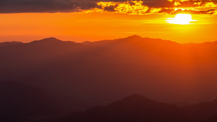 Hazy mountain range with dramatic sunset sky