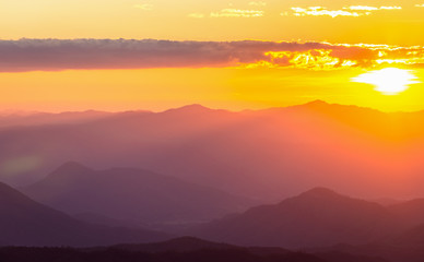 Hazy mountain range with dramatic sunset sky