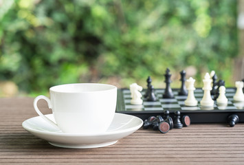 Coffee cup on table with Chess board
