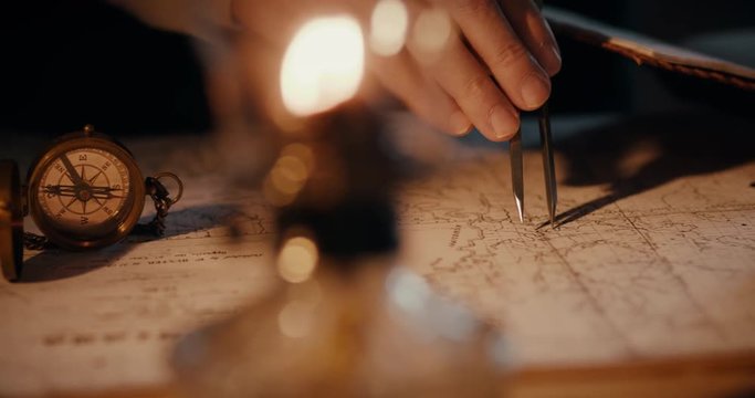 Different views of a vintage 1850 mapmaker using a compass divider going over a map taking notes