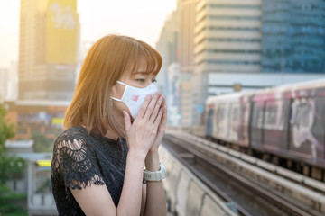 Asian woman wearing the N95 Respiratory Protection Mask against air pollution at sky train station