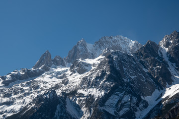Fototapeta na wymiar Jade dragon snow mountain situated in Yulong, Yunnan China. The snow covered mountain with rocky peaks giving a dramatic view.