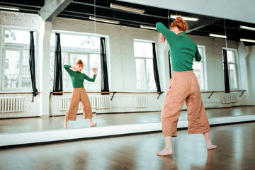 Obraz premium Young red-haired dance teacher with a hair bun spending her day in the studio