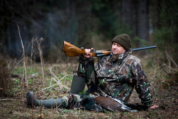 hunter with prey in the forest after hunting rests