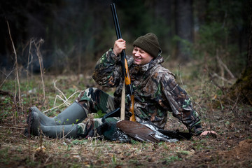 hunter with prey in the forest after hunting rests