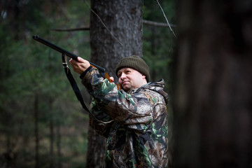 Obraz premium hunter with a gun in the forest cures prey