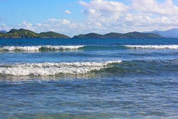 Virgin Islands US panorama from a shore of one of the beaches of St. Thomas Island in winter. Warm welcoming  waters of Caribbean Sea with a view on mountainous islands on horizon.