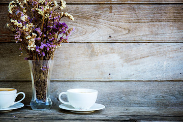 Obraz na płótnie Canvas Coffee cup and vase flower on wooden.