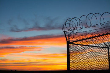 BSilouette of fence at sunset