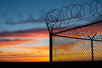 BSilouette of fence at sunset
