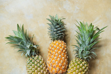 Pineapple on Stone Table Background Top Down View. Summer Exotic Fruit on Retro Tabletop Surface Copy Space. Healthy Ripe Tasty Whole Ananas on Rustic Yellow Texture Backdrop Overhead Closeup