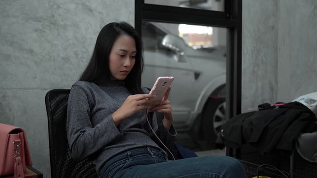 The pretty woman chatting on smartphone in waiting room