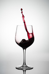 red wine splashing out of a glass	
