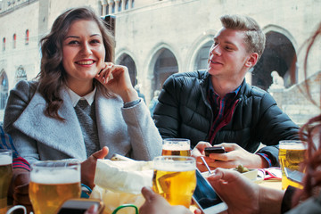 happy girl drinking beer with group of friends in a bar restaurant.
