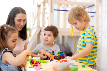 Obraz premium Kids learning to work colorful play dough in nursery, kindergarten or day care center