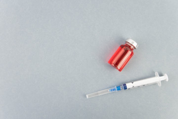 Medicine bottle for injection. Medical glass vials and syringe for vaccination. Liquid red drug or vaccine for treatment, flu in laboratory, hospital, healthcare, or pharmacy concept, isolated.