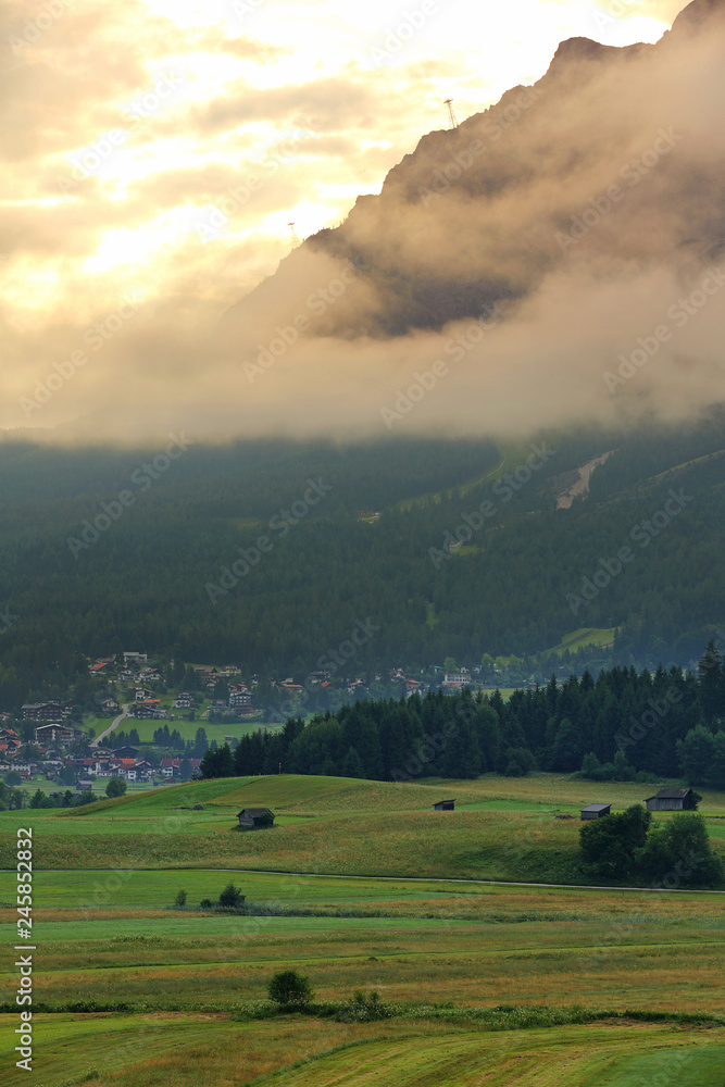 Wall mural summer of very large farm with the village and mt. zugspitze on the sunrise with fog , ehrwald, wett