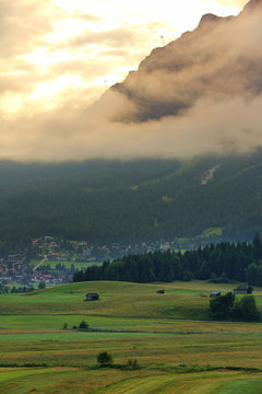 Summer of very large farm with the village and Mt. Zugspitze on the sunrise with fog , Ehrwald, Wetterstein mountain range at Biberwier, Tyrol, Austria 