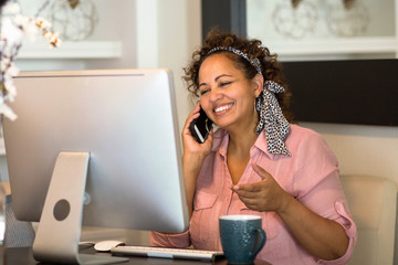 Mixed race woman working from her home office.