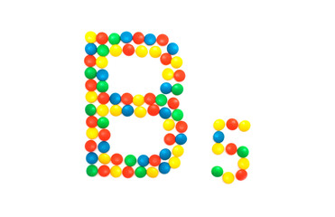 Multi-colored vitamins pills that are lined with the letter Vitamin group B5, close-up
