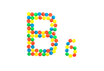 Multi-colored vitamins pills that are lined with the letter Vitamin group B6, close-up