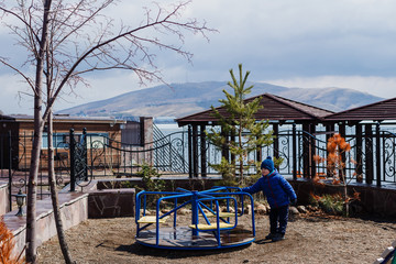 Fototapeta na wymiar a four-year boy playing on the playground in spring