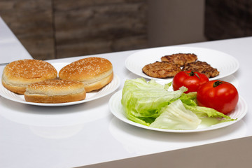 Ingredients in the kitchen for cooking fast food cheeseburger and hamburger, homemade, background, hamburger buns
