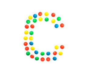 Multi-colored vitamins pills that are lined with the letter Vitamin C, close-up