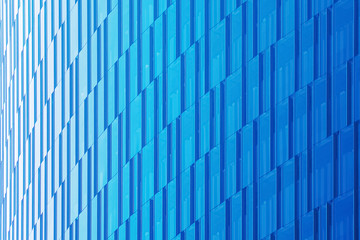 Geometric architectural urban background in blue tones. The glass facade of a skyscraper.