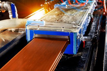 The wood floor factory's machine is flushing the wooden floor on the assembly line
