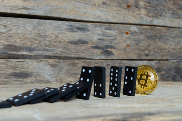 Domino and bitcoin coin on wooden background. Crash, Finance, inflation.
