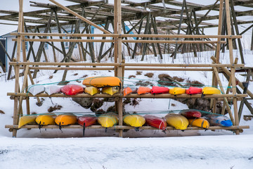 Colorful Kayak stored on wooden rack in winter