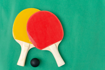 Red and yellow table tennis rackets with black balls,.table tennis rackets and balls on table.