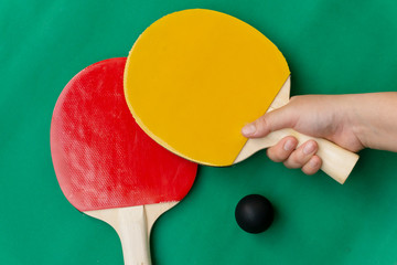 Red and yellow table tennis rackets with black balls,.table tennis rackets and balls on table.