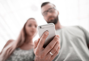 young couple looking photos on smartphone