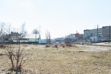 Fototapeta na wymiar gray field and old industrial buildings