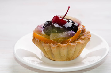 basket cake decorated with different fruit on white table