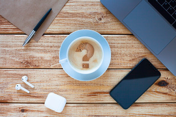 Top view of a laptop computer keyboard with phone, cup of coffee and headphones on the wooden background. Business, office and work concept. 