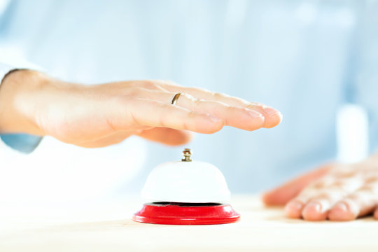 Service Concept. Businessman Hand Above Red Hotel Service Bell.