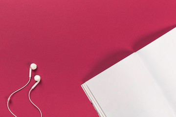 white headphones and a mocup magazine on a red background