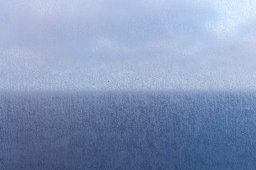 Fototapeta na wymiar Boat window with water drops in focus. Blue sky and the sea.