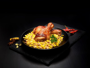 grilled chicken legs with sesame and rice on a black background.