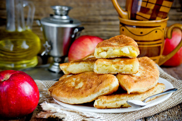 Fried apple pies from yeast dough stuffed with apple slices fried on pan