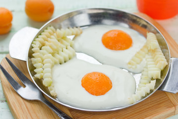 Healthy breakfast idea for kids - fried eggs with french fries made from cream, apricot and fresh apple