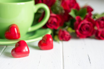 Valentine's day background with tea cup, sweets and red roses.