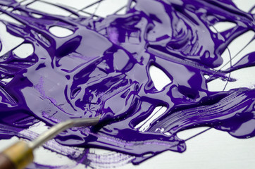 palette knife with purple paint on a white background