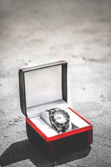 watch with gift box in sea sand, watch near the sea sand